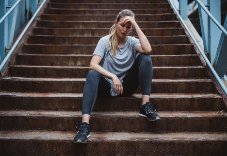 Woman sitting on stairs in exercise clothing-3 Ways to Break Out of a Running Slump